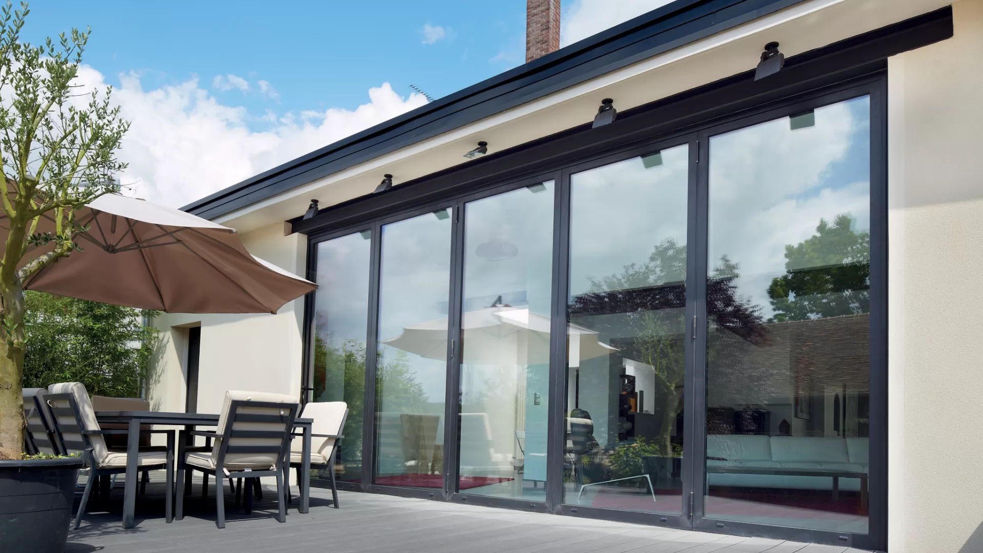 Aluminium bifold exterior door with five panels, looking out onto a modern patio