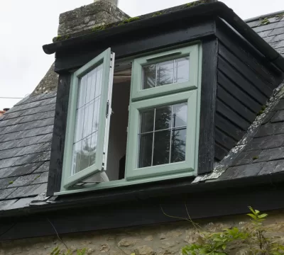 Green uPVC casement window with Georgian bars showing decorative glazing